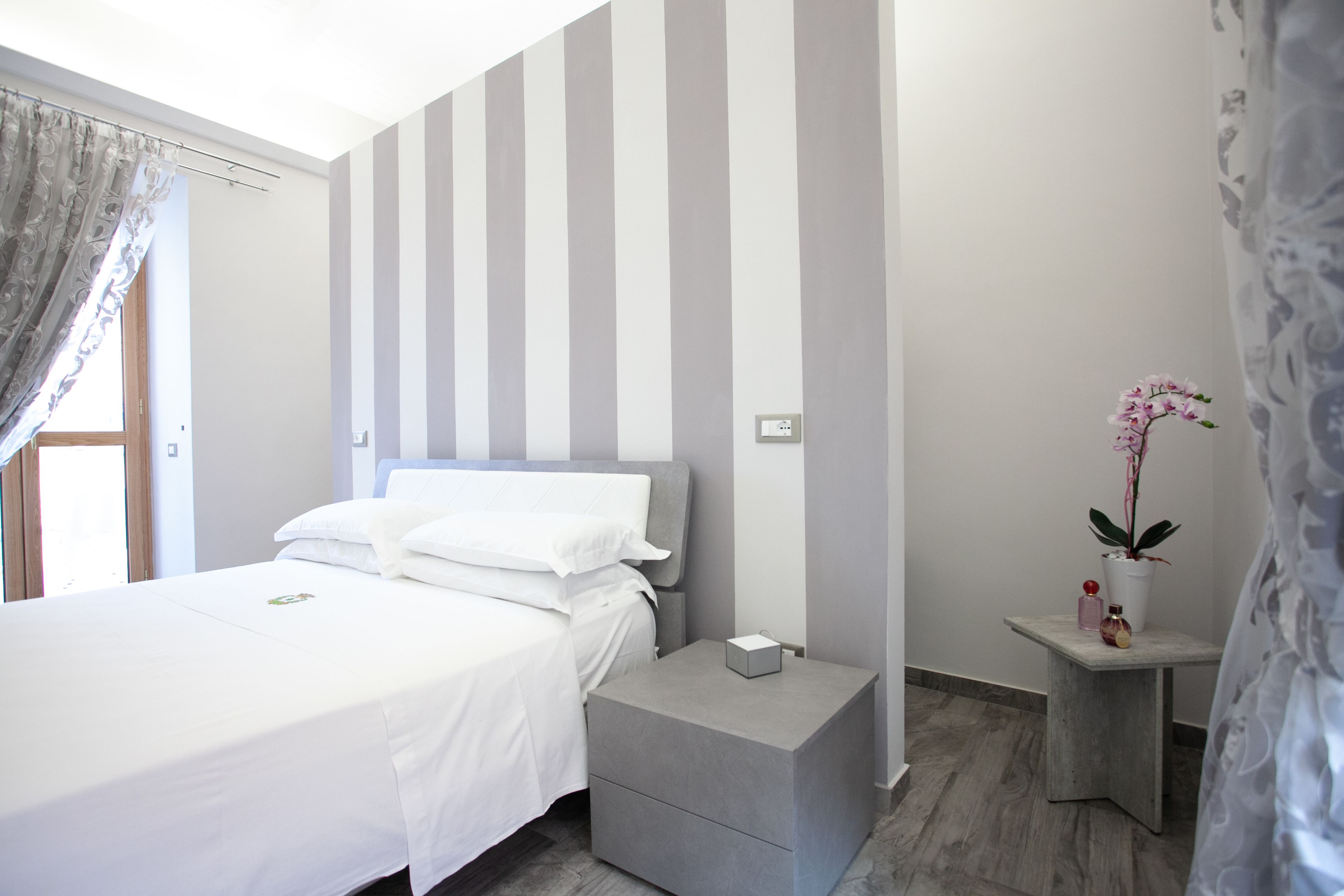 Een moderne slaapkamer met een bed, nachtkastje en een bijzettafeltje.