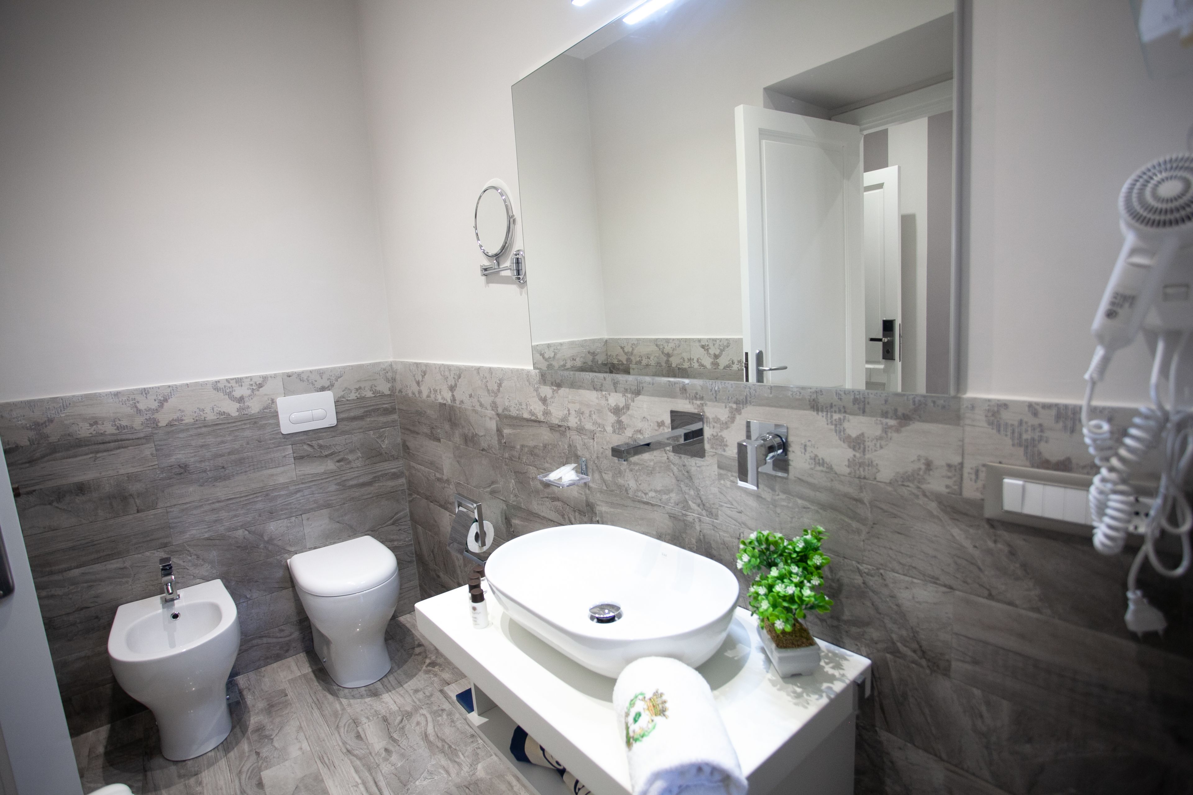 A modern bathroom with a bidet, toilet, and sink.