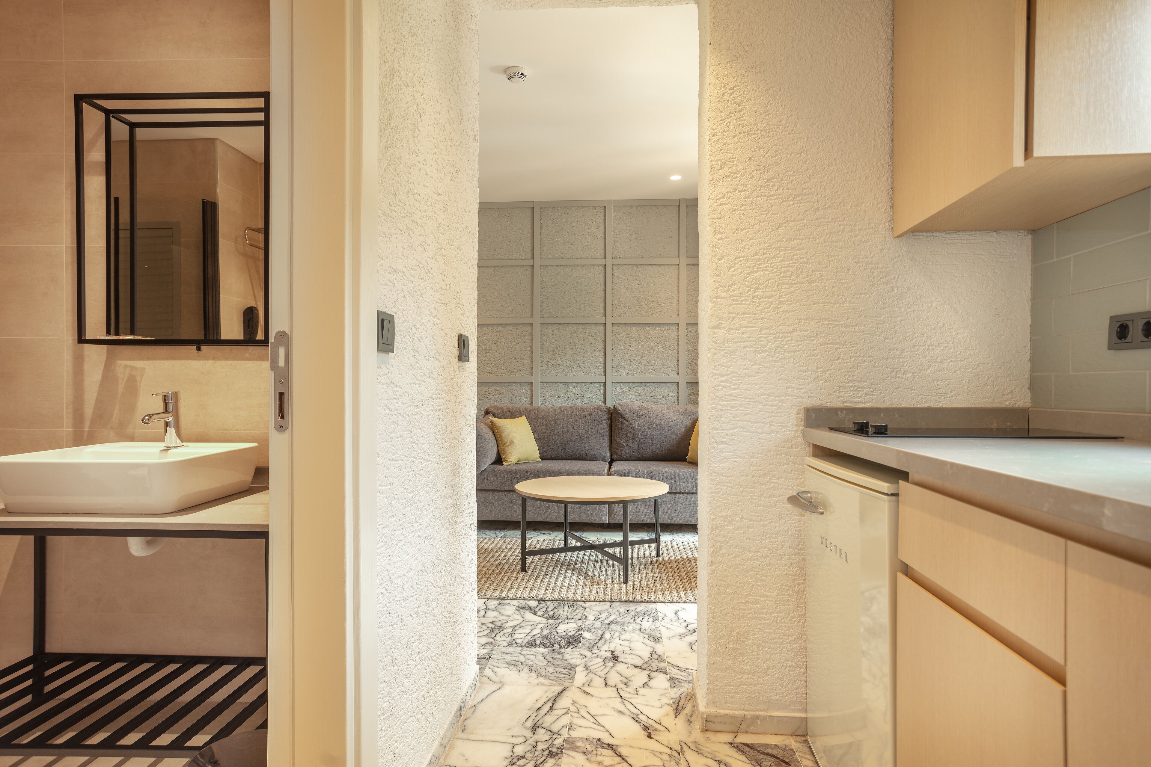 A modern bathroom with a sink, mirror, and a shower area.