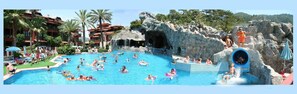 Un área de piscina con varias toboganes y una piscina central grande.