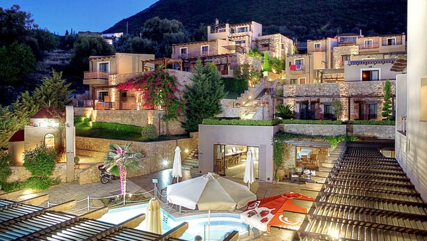 A hillside hotel with multiple buildings, outdoor seating, and a swimming pool. - Tesoro Hotel (Lefkada)