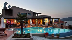A modern hotel with a swimming pool, outdoor seating, and a view of the sea. - Tesoro Hotel (Lefkada)