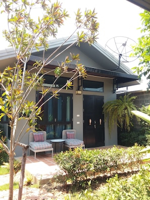 A modern house with a patio area featuring two chairs and a small table. - Amphawa Caza Platuu (Samut Songkhram)