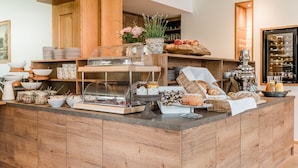 A buffet setup with various food items, including fruits, pastries, and condiments. - Landhaus Steiner (Altenmarkt im Pongau)