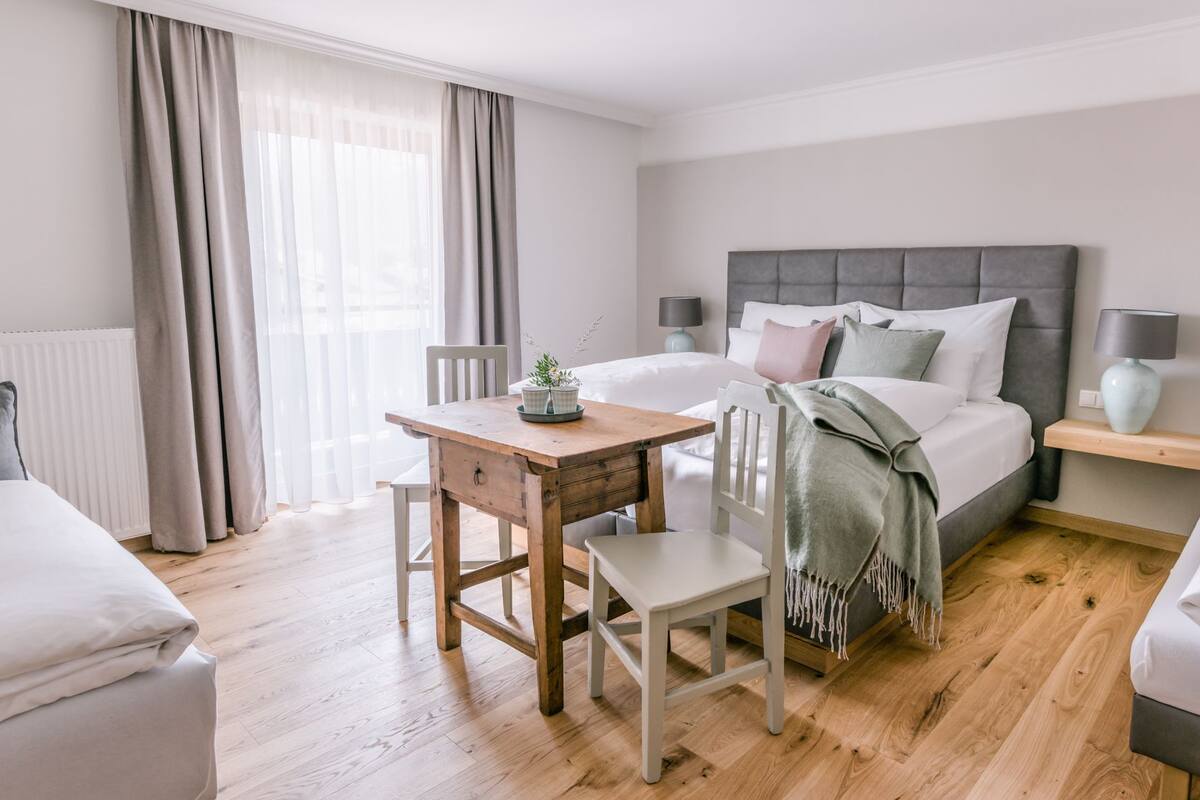 A bedroom with a bed, bedside tables, a desk, and a chair.