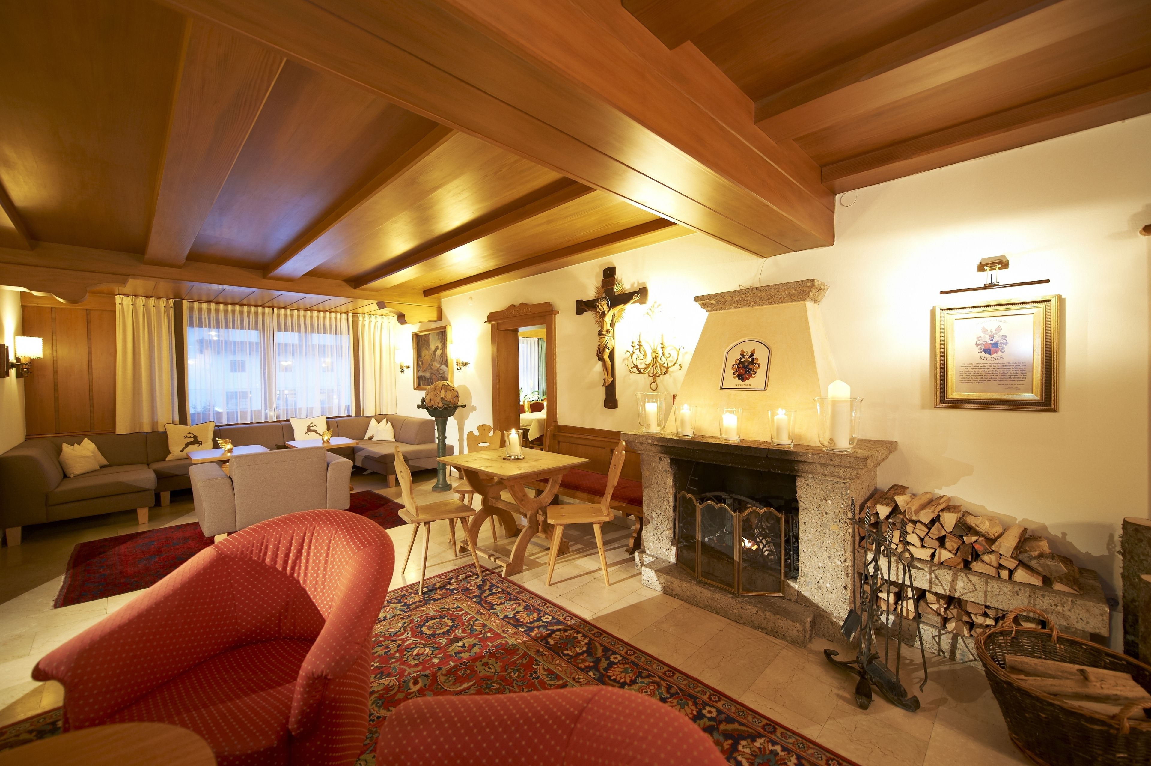 Una sala de estar acogedora con chimenea, vigas de madera y una cruz en la pared.