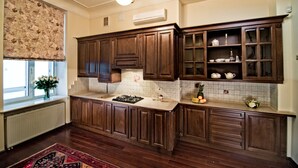 Una cocina con armarios de madera, una estufa y una ventana con un arreglo floral.