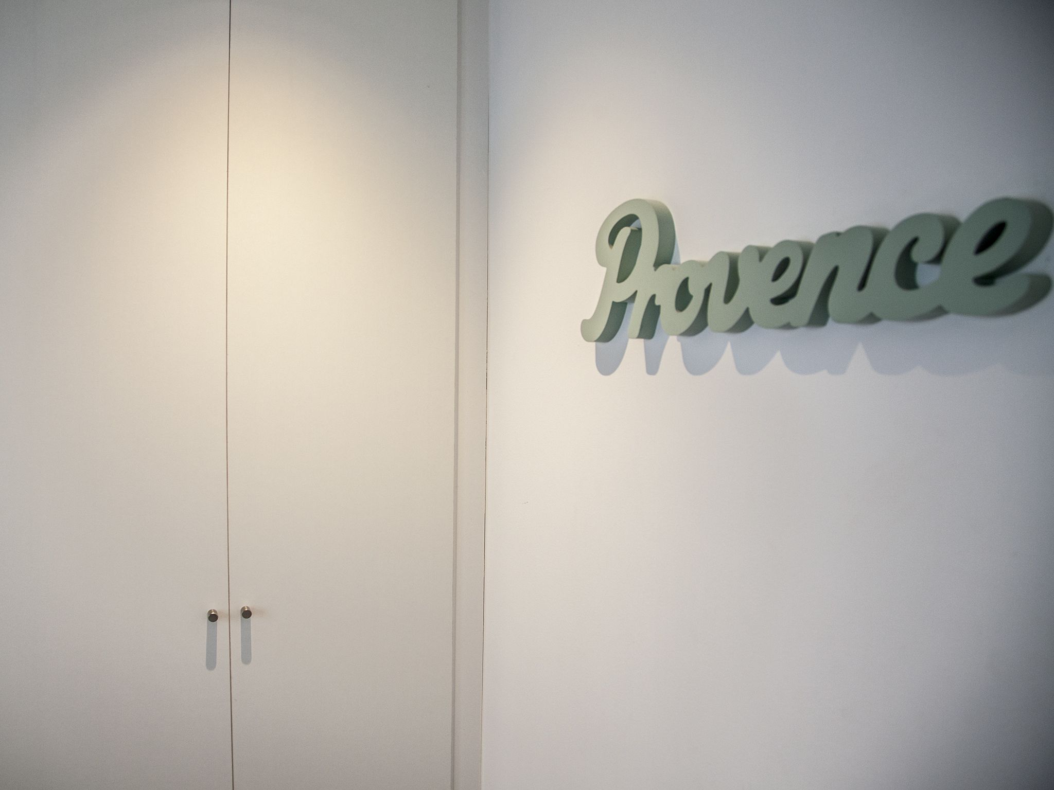 Une porte blanche, sur laquelle est affiché un panneau indiquant « Provence ».