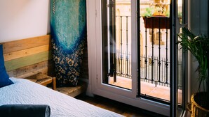 Una habitación con cama, ventana grande y una tabla de surf.