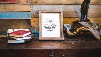 Una cita sobre viajes en un marco, sobre una superficie de madera con libros y una escultura de madera.