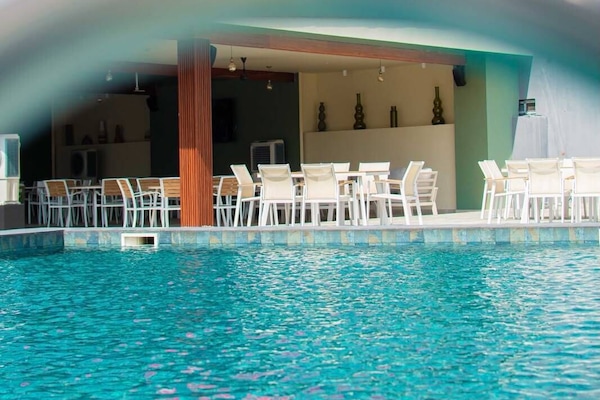 Piscina a l'aire lliure, para-sols i gandules