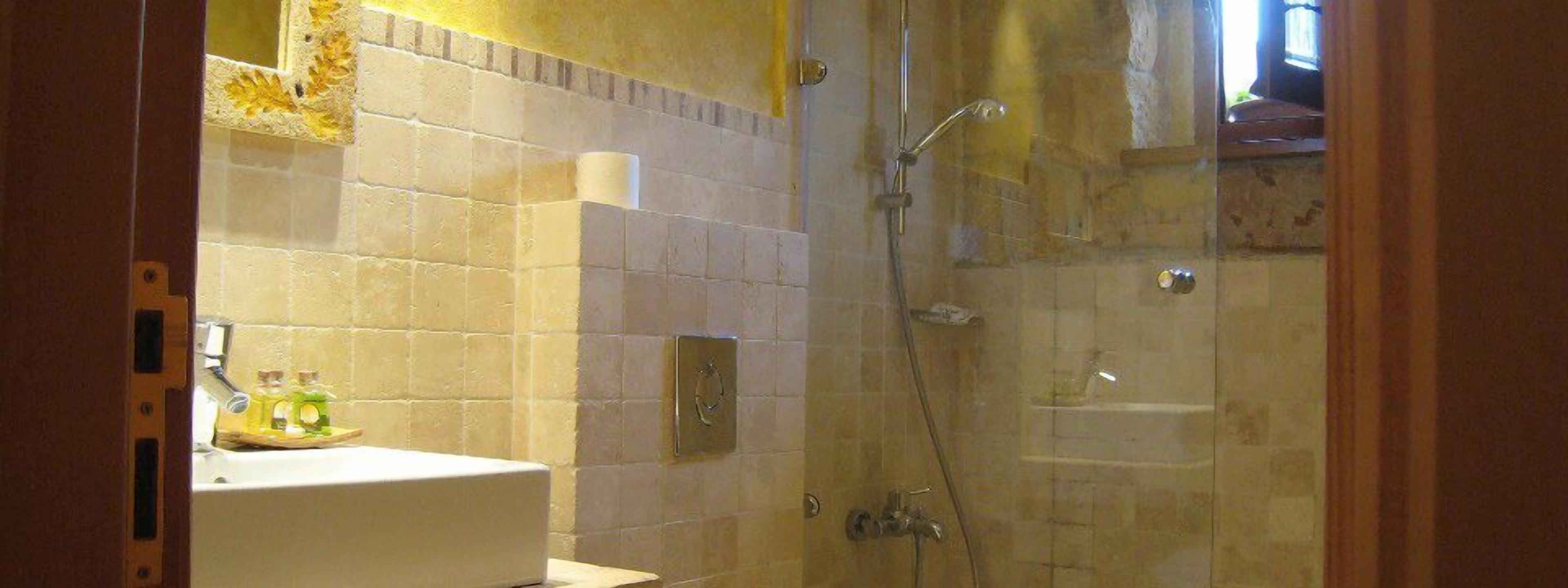A bathroom with a shower, a sink, and a mirror.