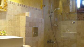 A bathroom with a shower, a sink, and a mirror.