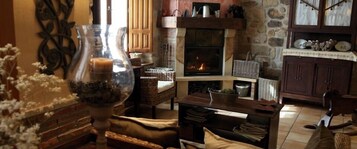 Uma sala de estar aconchegante com lareira, móveis de vime e objetos decorativos.