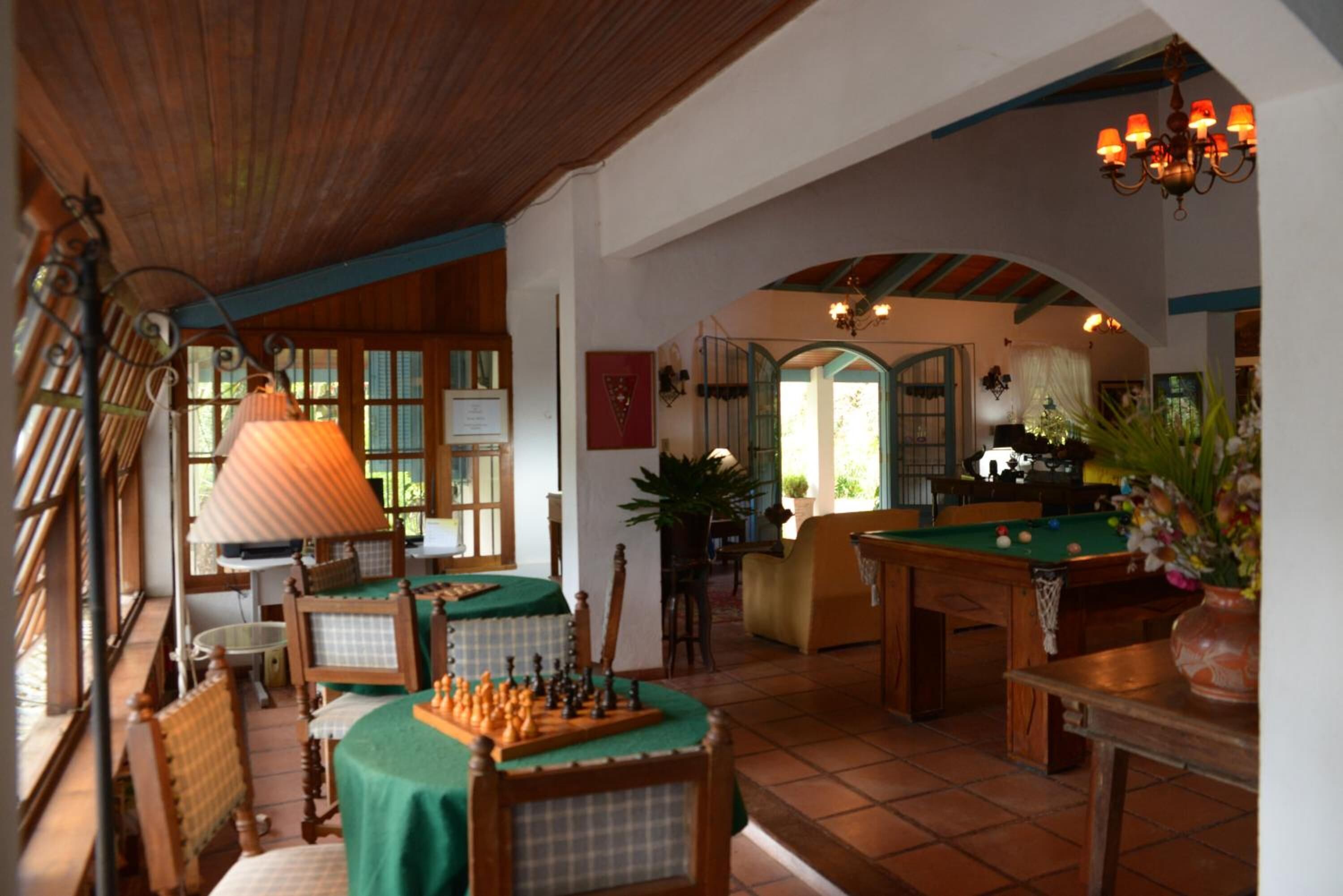 Une pièce chaleureuse équipée d’une table de billard, d’une table d’échecs et d’une table de jeu de fléchettes.