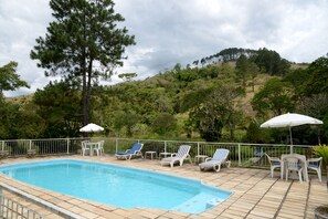 Una piscina al aire libre, tumbonas