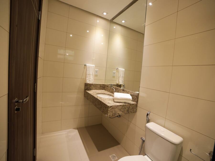Une salle de bain moderne avec un lavabo en marbre, des toilettes et une baignoire.