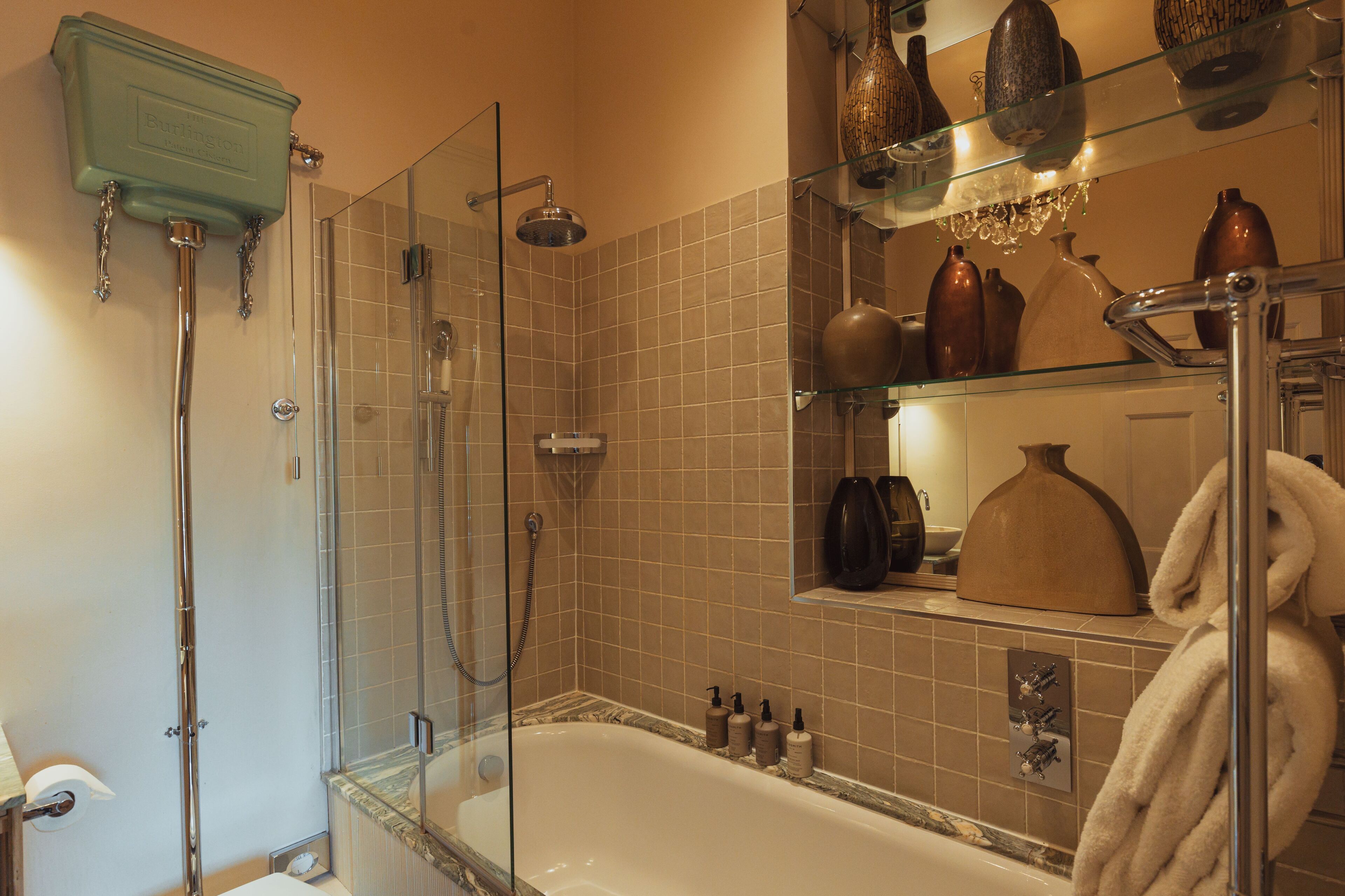 A bathroom with a glass-enclosed shower, a bathtub, and a vanity with a mirror.