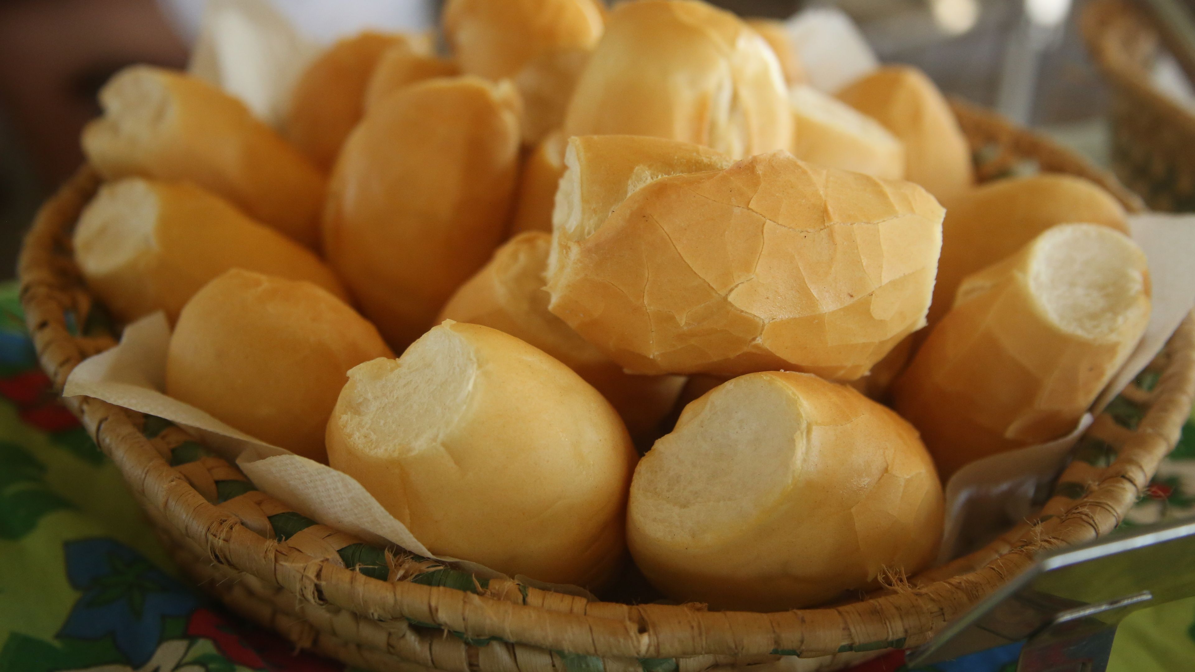 A basket of round, golden-brown bread rolls.