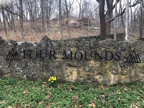 A stone wall with the text "FOUR MOUNDS" engraved on it.