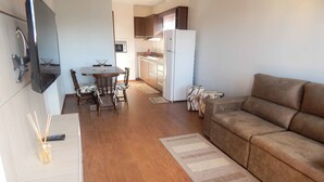 Un espacio habitable compacto con comedor, kitchenette y sofá.