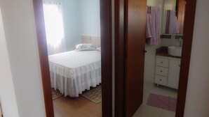 Un dormitorio con una cama, una mesita de noche y una ventana con cortinas.