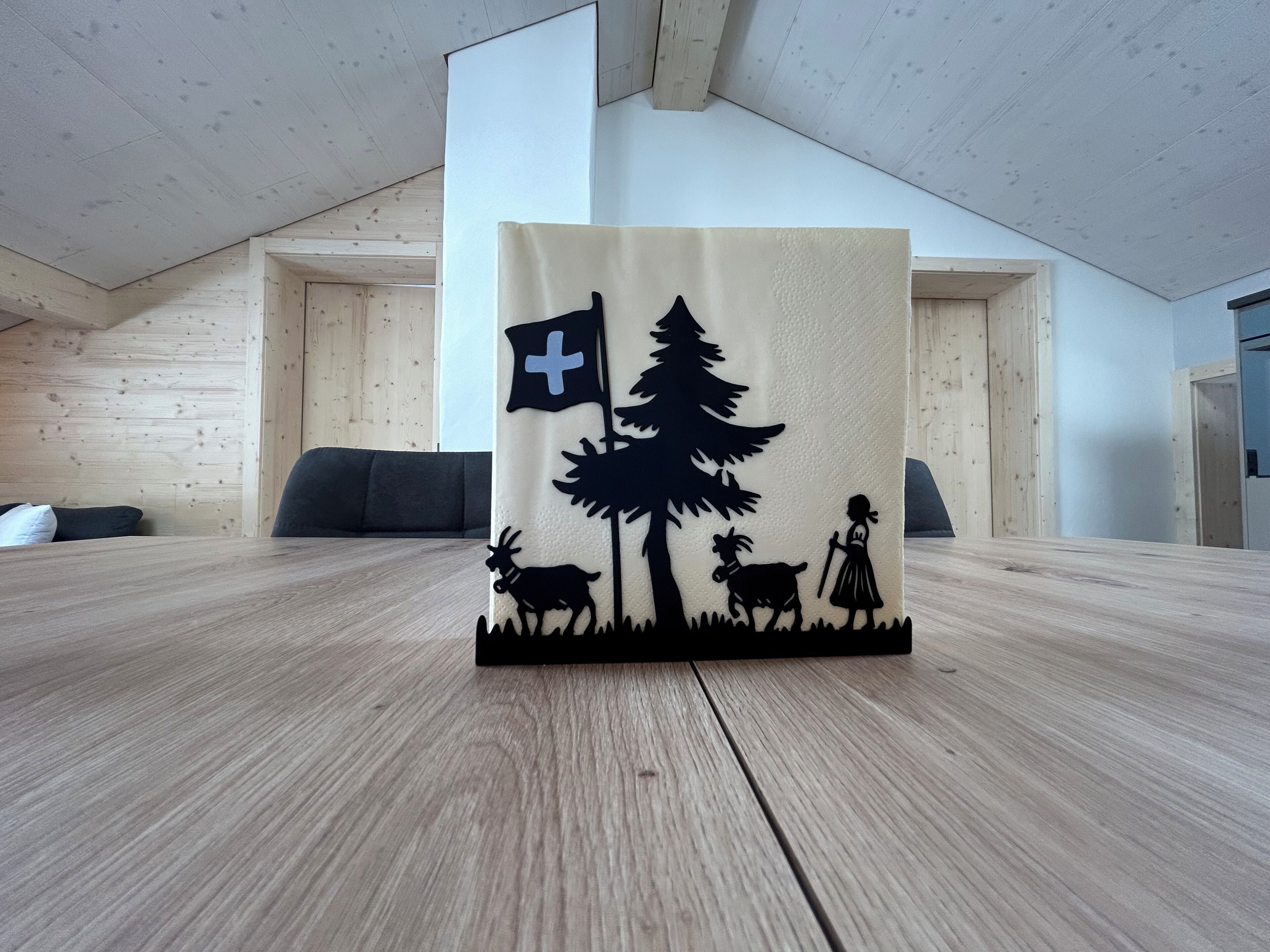 Une table ornée d’un objet décoratif représentant une croix, un arbre, ainsi que des figurines d’une personne accompagnée d’un chien et d’un cerf.