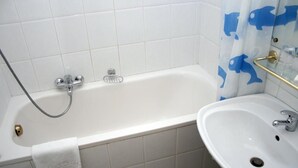 Un bagno con vasca, lavandino e tenda da doccia con motivo di delfini.