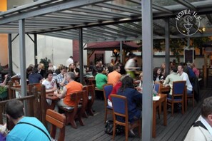 A restaurant with outdoor seating, covered by a metal roof, and a sign reading "HOTEL IFL". - ILF Hotel Prague (Prague)