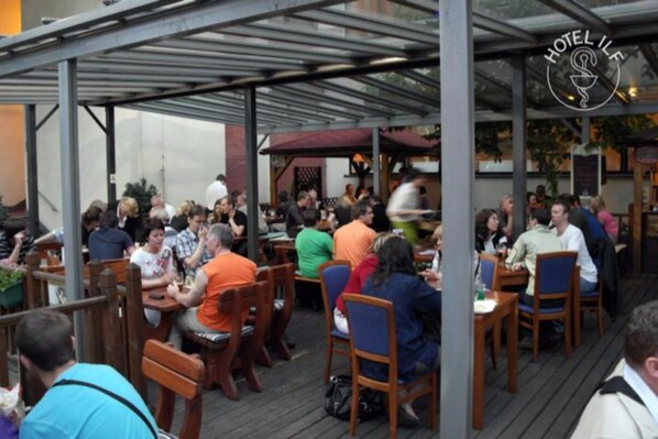 A restaurant with outdoor seating, covered by a metal roof, and a sign reading "HOTEL IFL". - ILF Hotel Prague (Prague)
