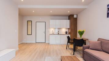 A modern apartment with a living room, kitchenette, and a dining area.