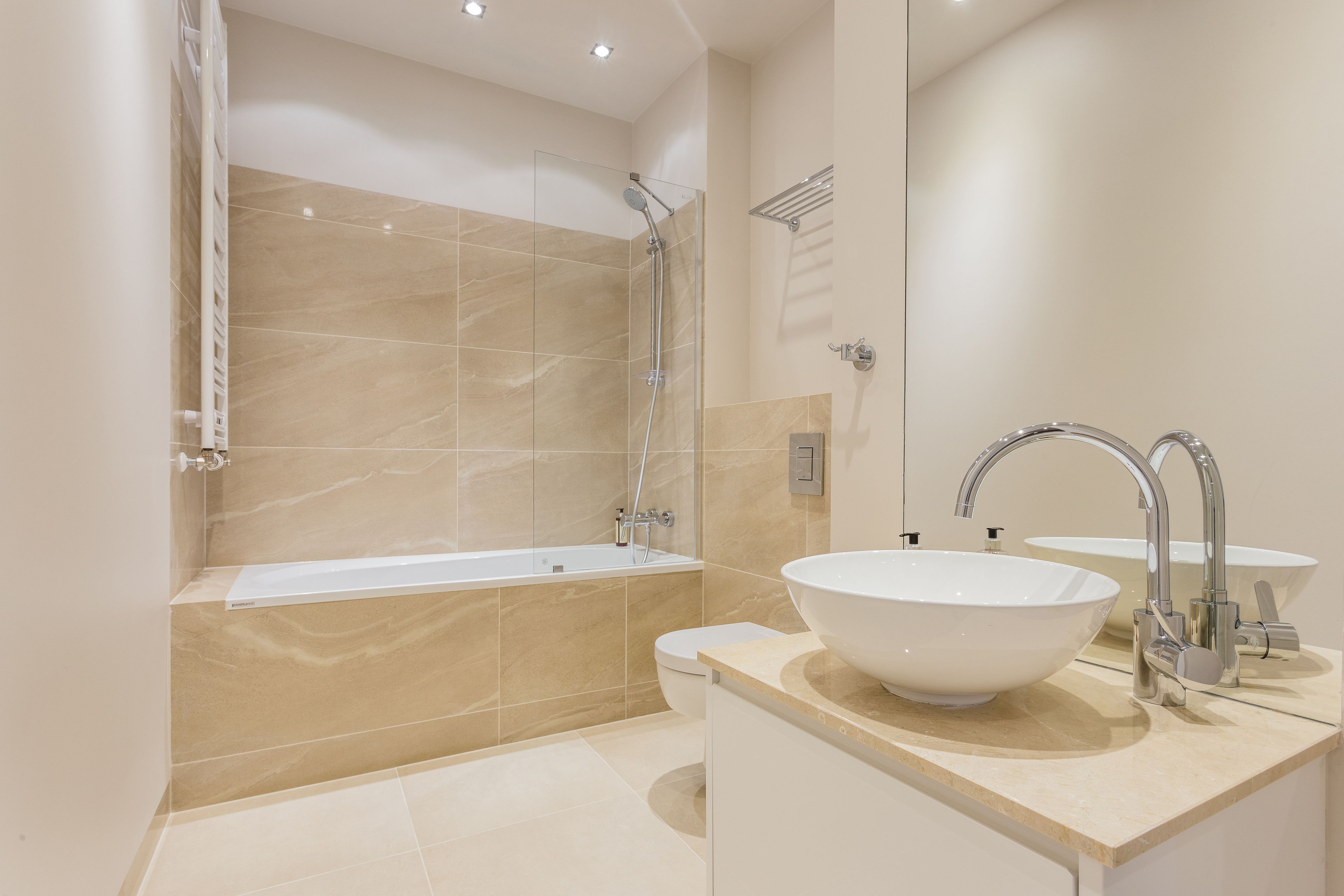 A modern bathroom with a bathtub, a large sink, and a toilet.