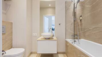 A modern bathroom with a toilet, sink, and shower.