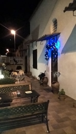 Ein Terrassenbereich im Freien mit einer Bank und Topfpflanzen.