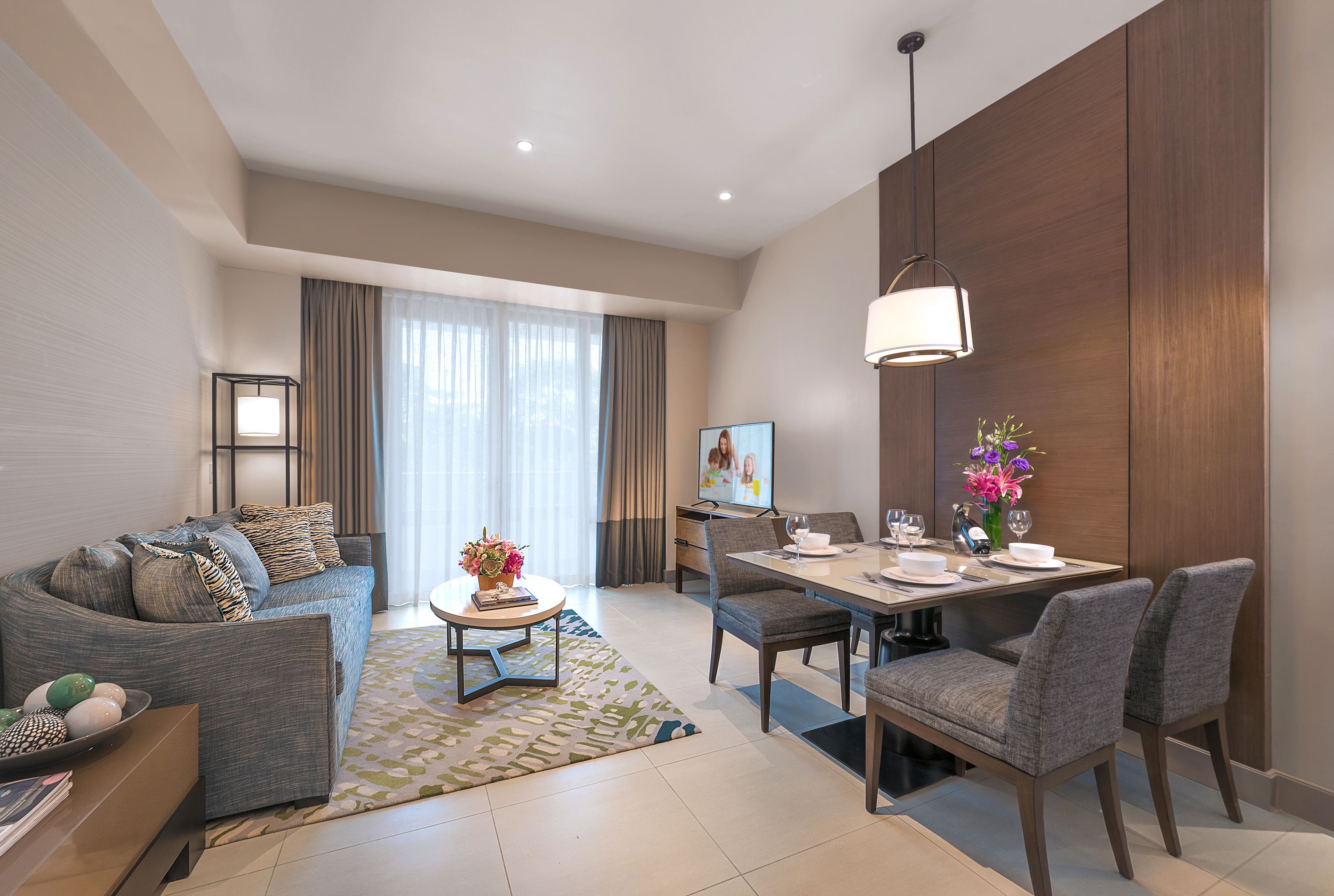 A modern living room with a sofa, coffee table, dining table, and chairs.