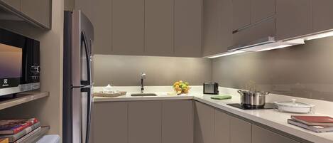 Una cocina moderna con refrigerador, microondas y horno integrados.
