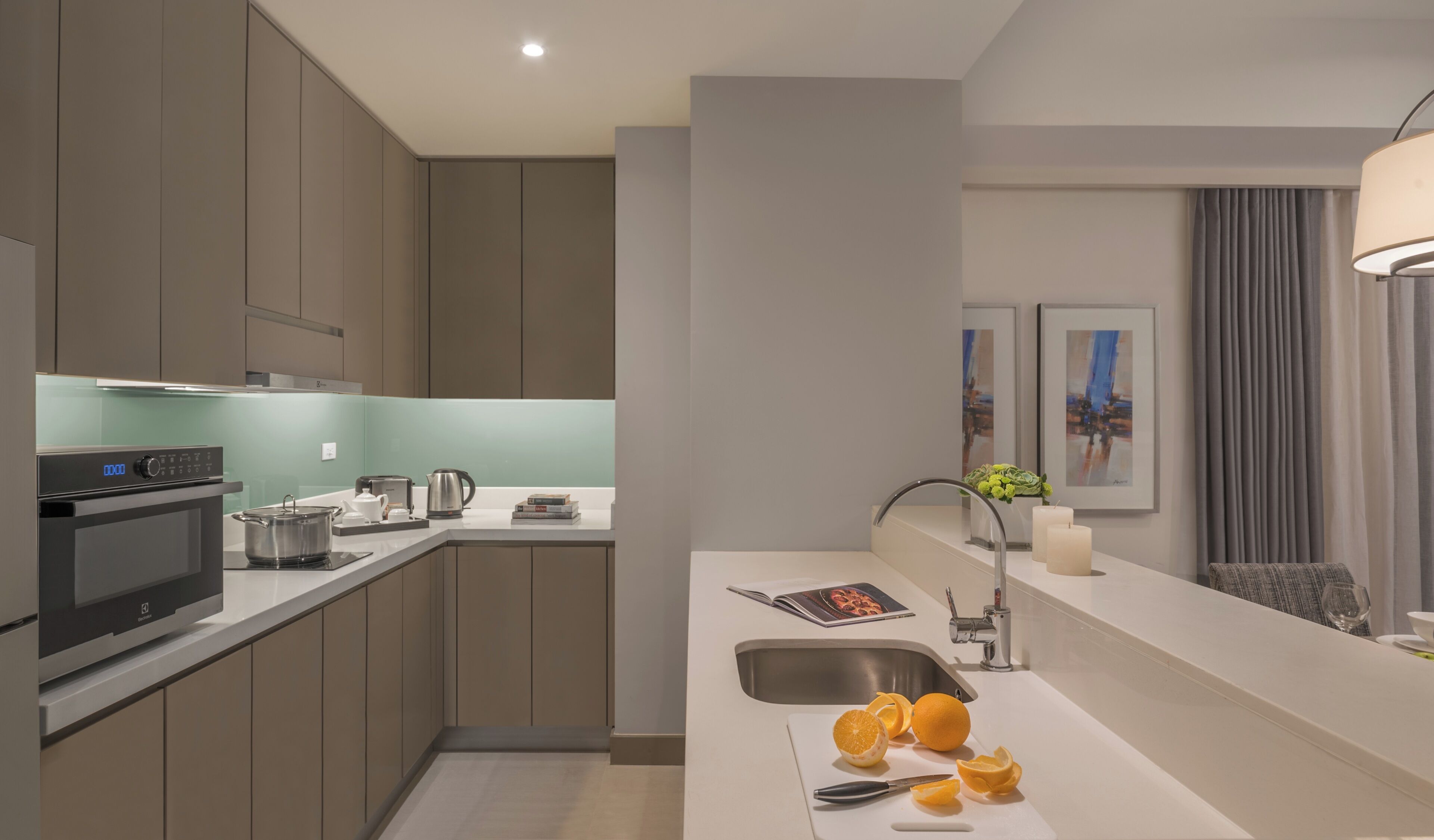 Una cocina moderna con electrodomésticos integrados, un lavamanos y una encimera con naranjas.