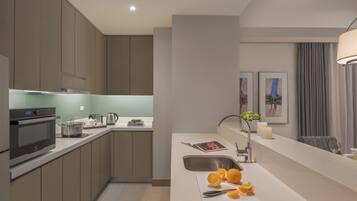 Una cocina moderna con electrodomésticos integrados, un lavamanos y una encimera con naranjas.