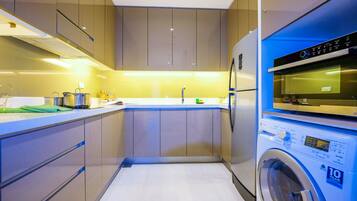 A compact kitchen with modern appliances, including a washing machine and an oven.