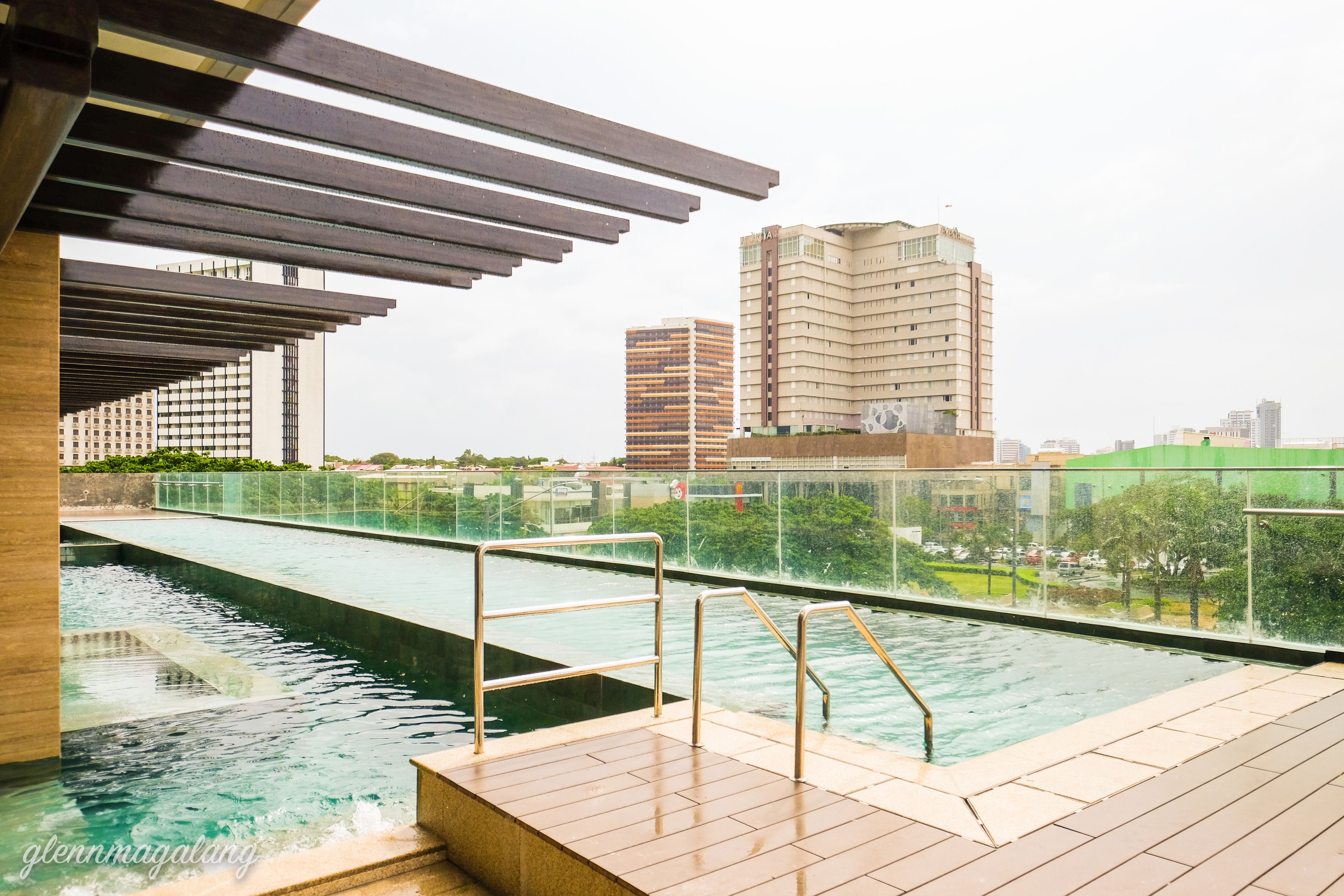 A rooftop swimming pool with a view of city buildings.