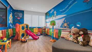 Children can play and learn in this vibrant room featuring a colorful play structure, toy car, and educational mural.