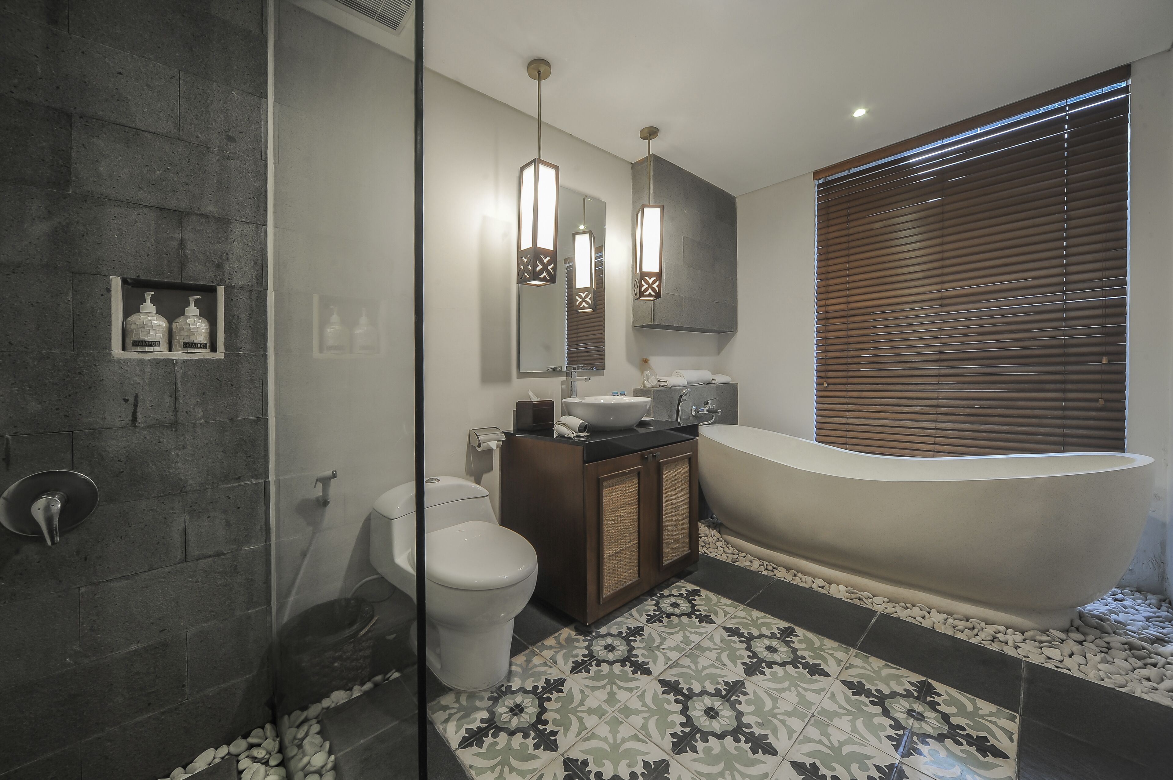 A modern bathroom with a freestanding bathtub, a toilet, and a shower area.