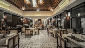Un restaurante con techo alto, suelo estampado y mobiliario de madera.