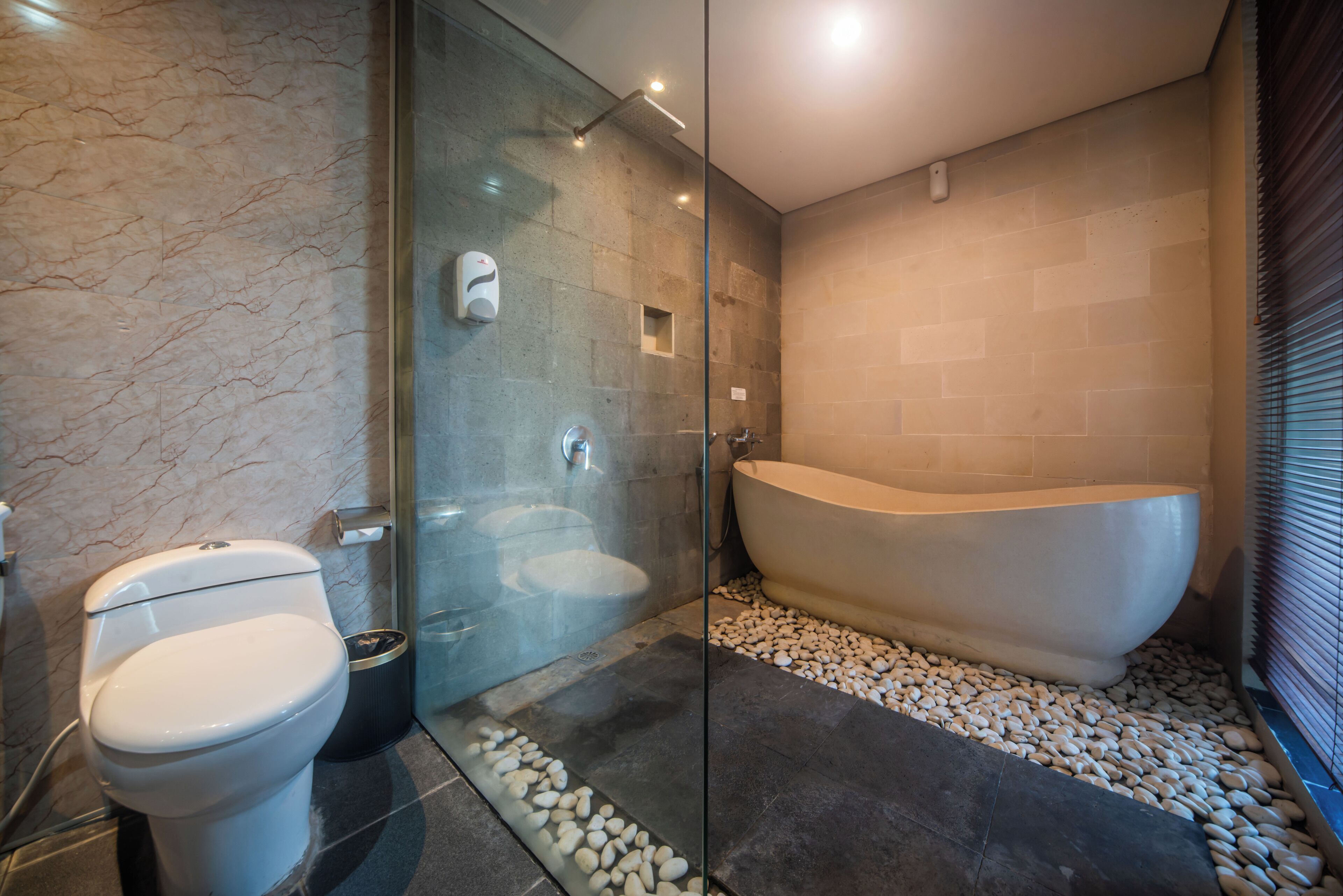 A modern bathroom with a glass-enclosed shower, a freestanding bathtub, and a toilet.