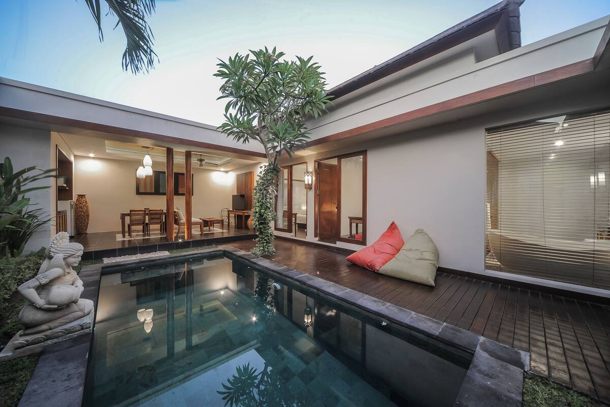 A modern house with a swimming pool, a dining area, and a cozy seating area.