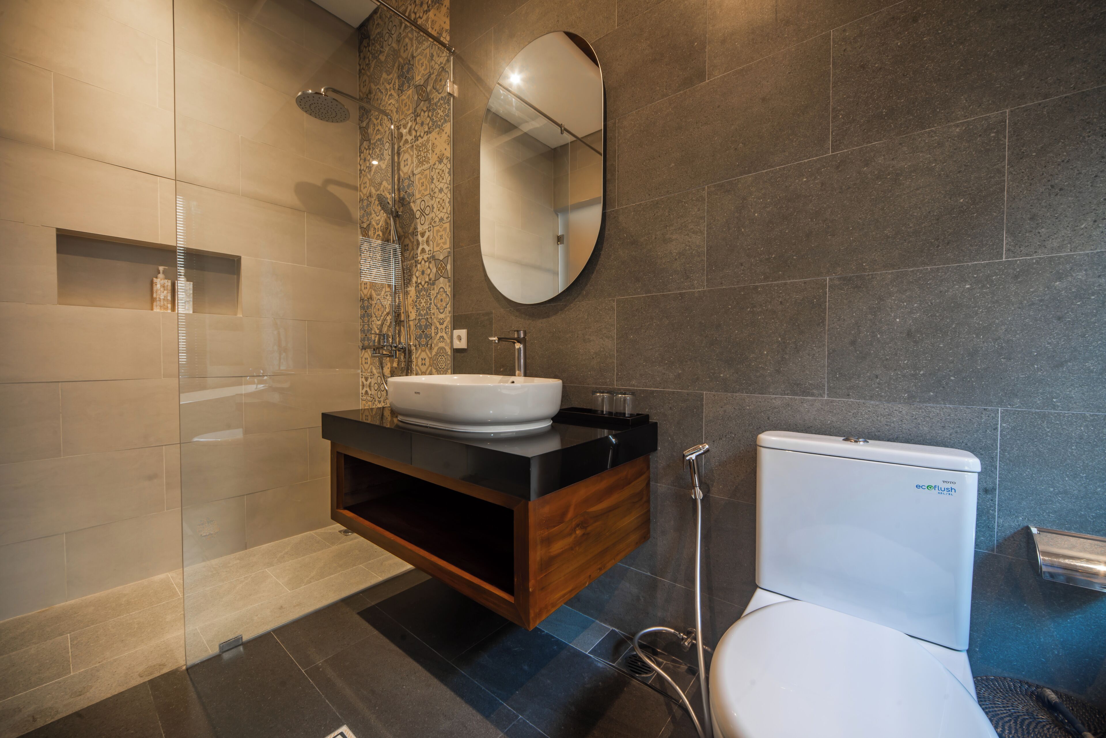 A modern bathroom with a freestanding sink, a toilet, and a shower.