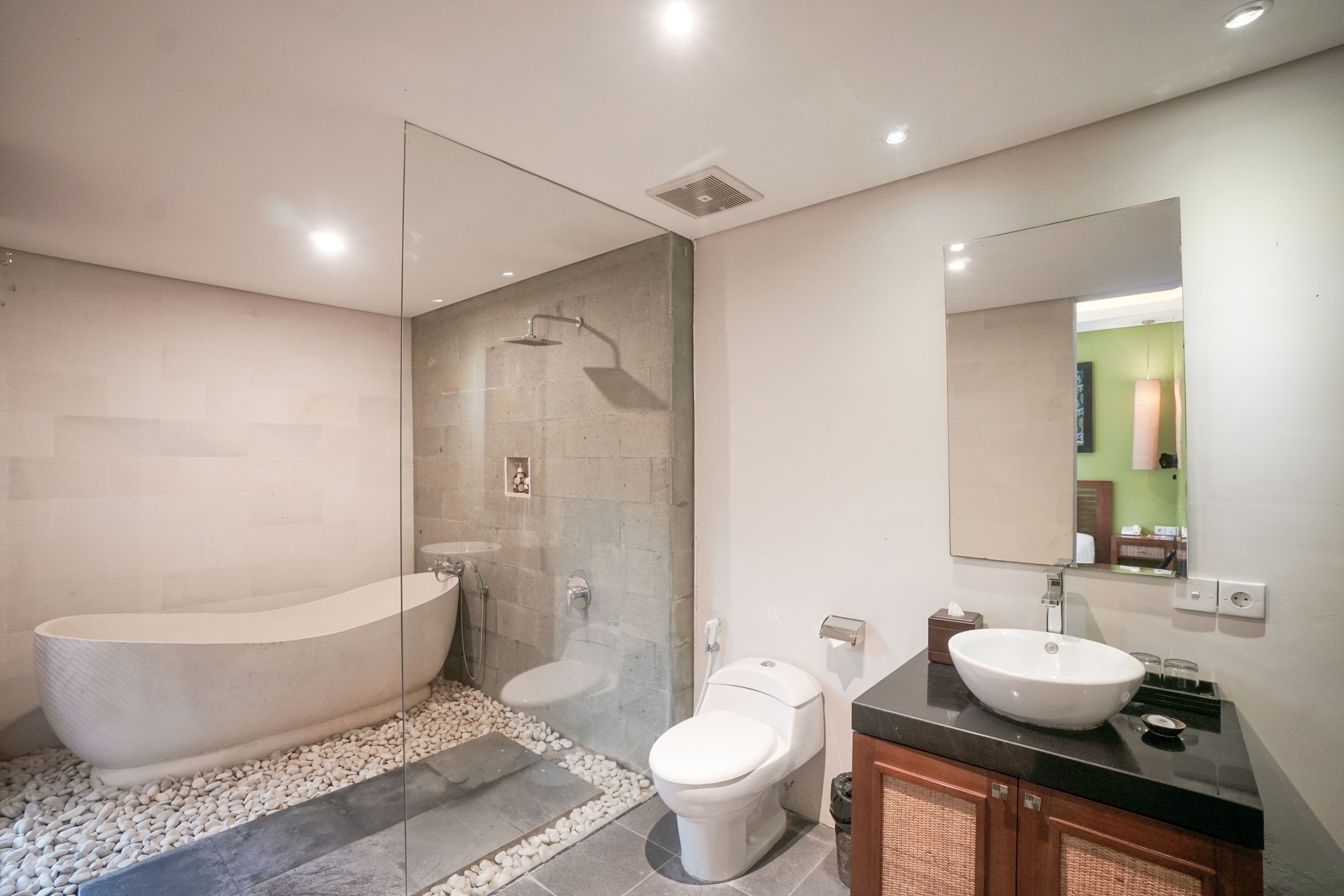 A modern bathroom with a freestanding bathtub, a glass-enclosed shower, a toilet, and a vanity with a sink.