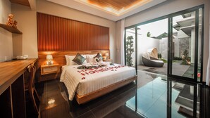 Una habitación de hotel moderna con una cama grande, cabecera de madera, mesitas de noche con lámparas, una puerta de cristal que da a un espacio exterior y techo de madera.