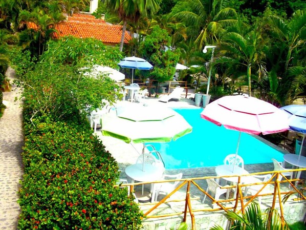 Una piscina al aire libre, sombrillas, tumbonas