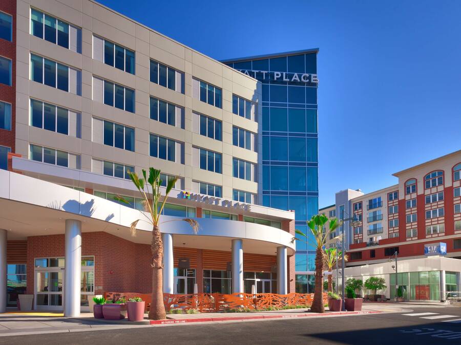 A modern hotel with a curved facade, large windows, and a prominent 'HYATT PLACE' sign.